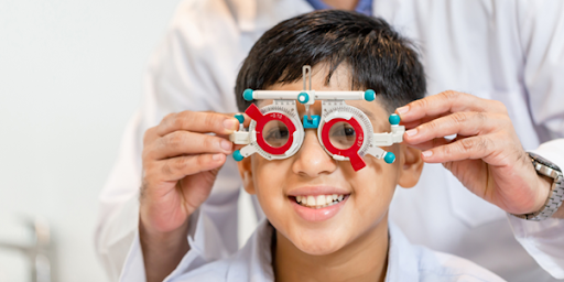 Young_boy_undergoing_an_eye_examination_with_a_trial_frame_conducted_by _an_eye_specialist_smiling confidently.