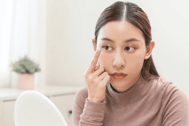 Woman_applying_a_contact_lens_with_a_focused_expression.